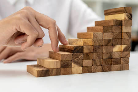 A close-up shot of a two-fingered hand gesturing similar to walking up a ladder on a wooden block...