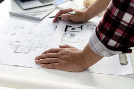 Professional home designers architects are reviewing the design plans before discussing the details with clients. Interior design and decoration ideas.の写真素材