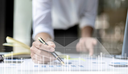 A businesswoman examines data on financial documents, company financial reports, graphics showing financial and numerical growth data. The concept of financial management to grow and be profitable.の写真素材