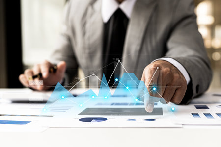 A businesswoman examines data on financial documents, company financial reports, graphics showing financial and numerical growth data. The concept of financial management to grow and be profitable.の写真素材