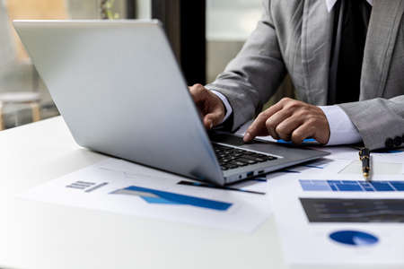 Close-up A businessman working in a private room, He is typing on a laptop keyboard, He uses a...