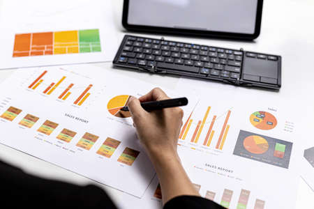A business finance woman is reviewing a company's financial documents prepared by the Finance...