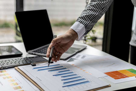 A business finance woman is reviewing a company's financial documents prepared by the Finance Department for a meeting with business partners. Concept of validating the accuracy of financial numbers.の写真素材