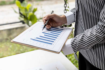 A business finance woman is reviewing a company's financial documents prepared by the Finance...