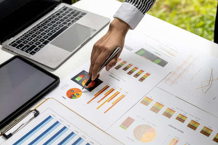 A business finance woman is reviewing a company's financial documents prepared by the Finance...