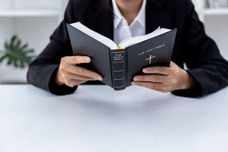A person is reading the Bible, he is praying to the Bible, he is reading and studying the Bible. Concept of Christianity and Bible Study.の写真素材