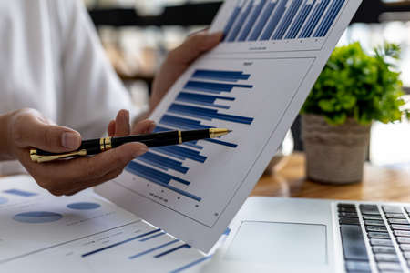 Business men are looking at the company's financial documents to analyze problems and find solutions before bringing the information to a meeting with a partner. Financial concept.の写真素材