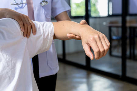 A physical therapist is doing physical therapy on a patient, the patient has muscle dysfunction due to hard work, most often an office worker who has problems sitting for long periods of time.の写真素材