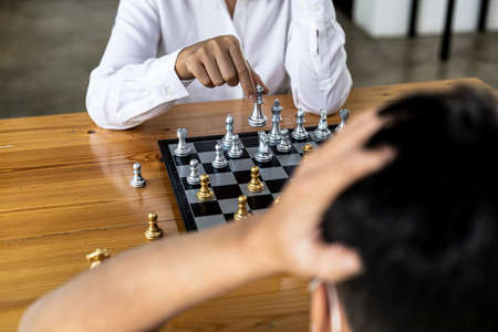 Two people playing a game of chess, concept image of two businessmen playing chess compared to a...