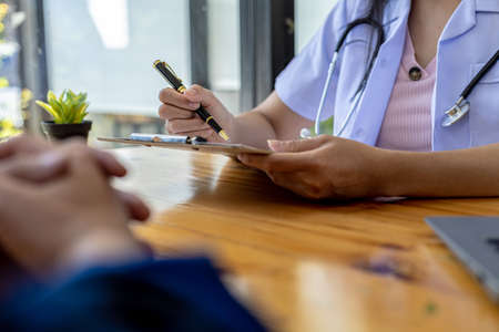 The doctor shows a document informing the results of the examination, the doctor explains the results of the tests found and treatment guidelines. Concept of examination and treatment of disease.の写真素材