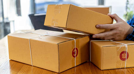 Asian man checking parcel boxes for customers, He owns an online store, He takes orders from...