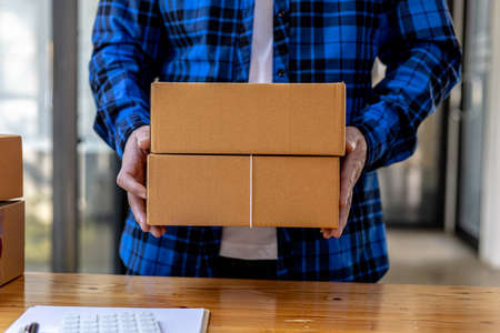 Asian man lifting a bunch of parcels, He owns an online store, He packs and ships through a private transport company. Online selling and online shopping concepts.の写真素材