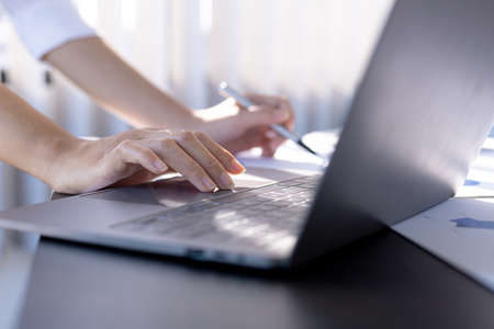 Businesswoman viewing financial data on laptop, she is reviewing financial data to bring to meetings with business partners. Concept of company financial management. Checking financial information.の写真素材