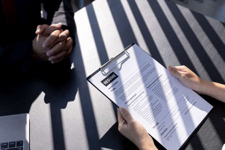 The HR department is reviewing the resumes of job applicants, resumes are important documents for job application. It should contain resume, training history, education, talent, work skills, etc.の写真素材