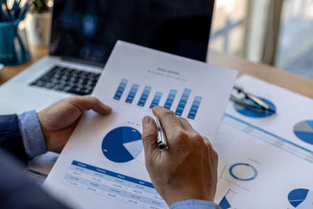 Business men are looking at the company's financial documents to analyze problems and find solutions...