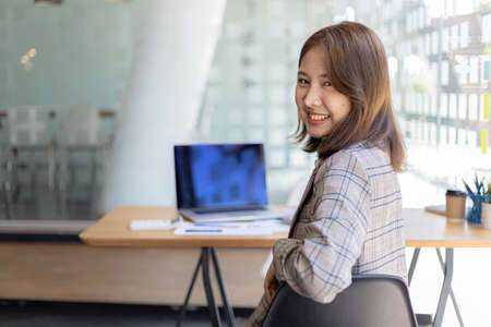 Portrait of a young beautiful Asian woman in a office room, concept image of Asian business woman, modern female executive, startup business woman, business leader woman.の写真素材