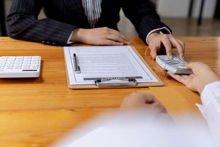 Businessmen are getting a lot of dollars from their business partners as money for bribery, bribery is an illegal act, corruption concept. Panorama banner background with copy space.の写真素材