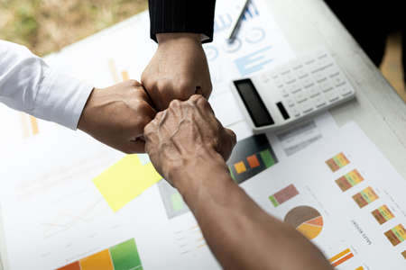 Three people put their fists together, businessmen joint venture start up companies, they are young entrepreneurs start up companies. up together to manage a plan to make the company profitable.の写真素材