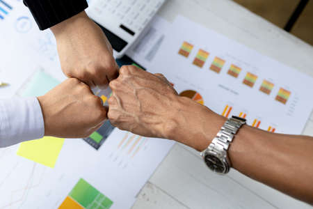 Three people put their fists together, businessmen joint venture start up companies, they are young entrepreneurs start up companies. up together to manage a plan to make the company profitable.の写真素材