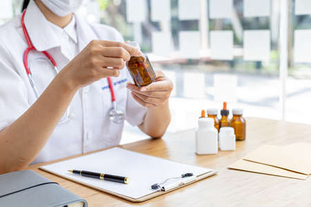 Pharmacy is holding a bottle, a public health professional with the most expertise in medicine in the health profession, responsible for all medicines, their procurement, production, and distribution.の写真素材