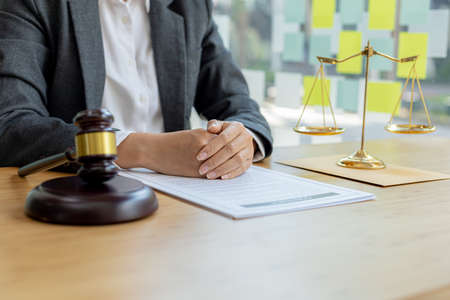 A lawyer sits in his office, on a table with a small hammer to beat the judge's desk in court. and...