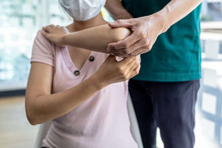 Physiotherapist is doing physical therapy for a patient, the patient has body aches due to overwork and has undergone treatment and physiotherapy with a professional physiotherapist.の写真素材