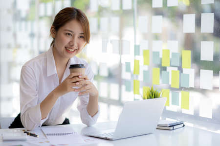 Beautiful Asian woman is a businesswoman who leads a new generation of startups, a woman who runs and manages a business plan to build confidence and stability in business, woman-led business concept.の写真素材