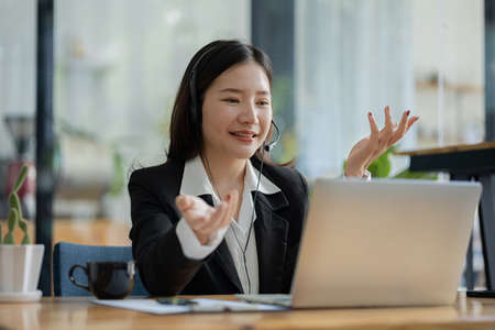 Beautiful Asian woman, she is a call center employee of an Internet and telephone company, she is...