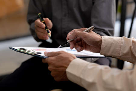 The atmosphere in the meeting room where the businessmen are meeting, information papers and charts are placed on the table to support the business planning meeting to grow. Business idea.の写真素材