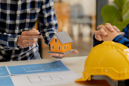 Architects design team is looking at models of small houses, Architect engineers design houses and...
