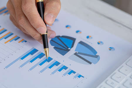 Business men are looking at the company's financial documents to analyze problems and find solutions before bringing the information to a meeting with a partner. Financial concept.の写真素材