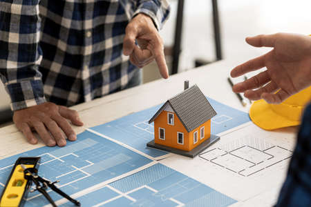 Architects design team is looking at models of small houses, Architect engineers design houses and...