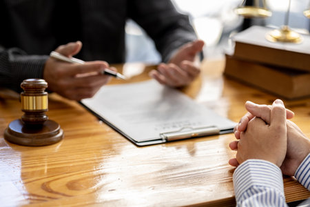 Client was listening to a lawyer advising on an embezzlement case, explaining the details of the proceeding and gathering evidence to file a lawsuit against the defendant. The concept of litigation.の写真素材