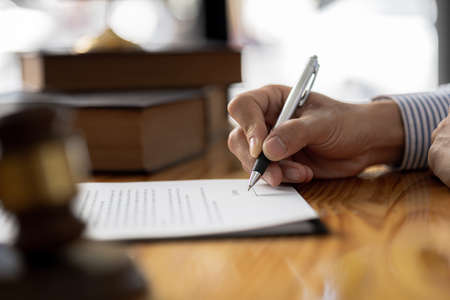 The individual is signing a contract agreeing to hire an attorney after consulting and providing...