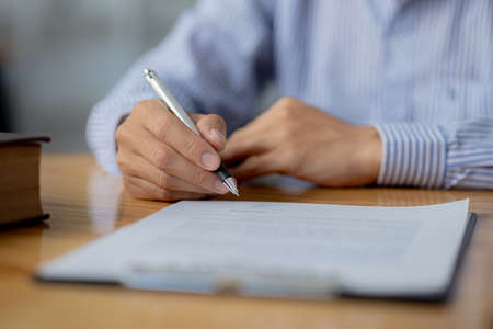 The individual is signing a contract agreeing to hire an attorney after consulting and providing...