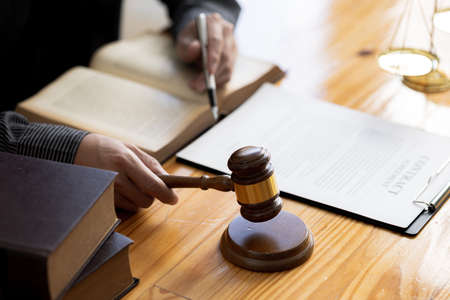 A person holding the hammer of justice, the concept of a lawyer or a law enforcement officer is...