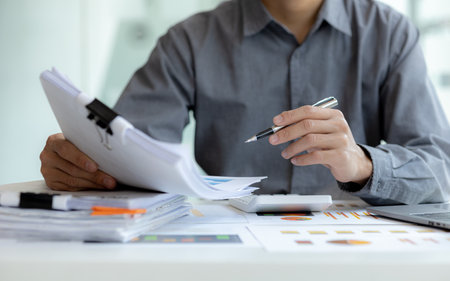 Business man pointing to a chart document showing company financial information, He sits in a private office, a document showing company financial information in chart form. Financial conceptsの写真素材