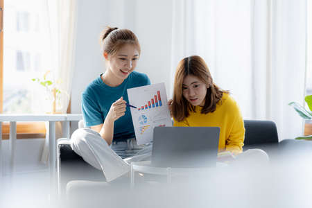 Two women in the living room, they are working from home due to the COVID-19 situation, they are...