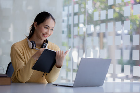 Beautiful Asian woman using a laptop to study online, she is studying online. The concept of online...