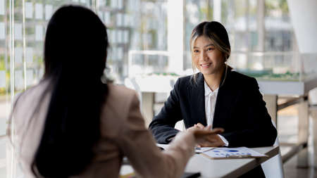 Atmosphere in the office of a startup company, two female employees are discussing, brainstorming...