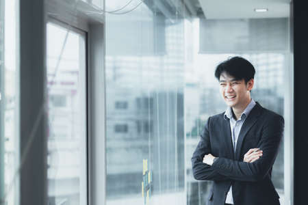 Asian man with suit, young businessman as startup company CEO, executive room, young startup company executives, run by young leaders. Management concept of startup companies and business men.の写真素材