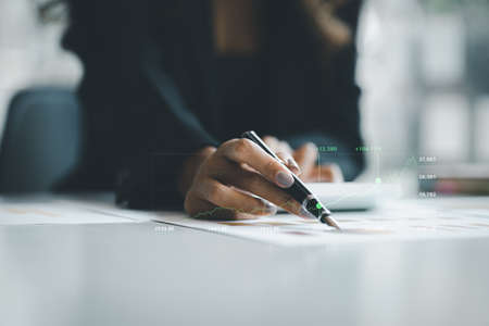 A business woman examines data on financial documents, company financial reports, graphics showing...