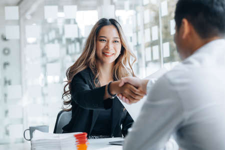 Business investor group holding hands, Two businessmen are agreeing on business together and shaking hands after a successful negotiation. Handshaking is a Western greeting or congratulation.の写真素材