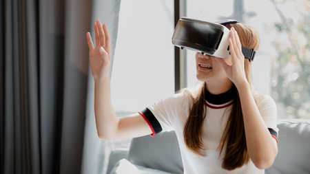 Woman wearing virtual reality glasses to use the technology of the future, using virtual reality...