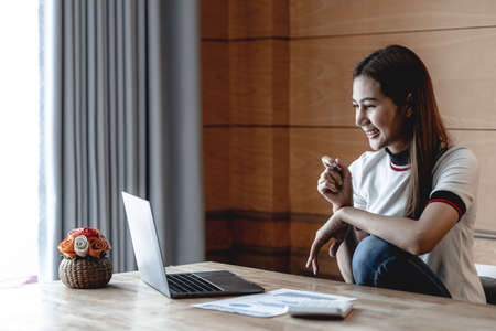 A woman works with a laptop, she is an employee of a startup company, she works from home due to the...