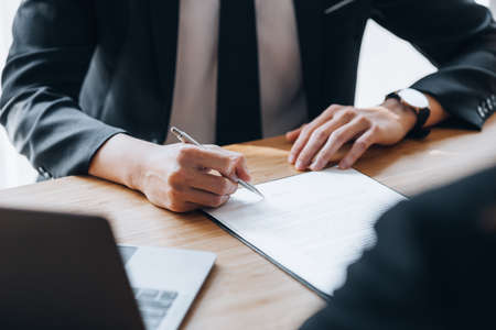 Client was listening to a lawyer advising on an embezzlement case, explaining the details of the proceeding and gathering evidence to file a lawsuit against the defendant. The concept of litigation.の写真素材