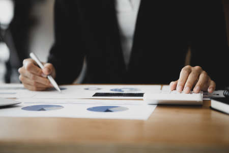 Business woman checking financial documents, she owns a startup company, she sits checking the company's financial summary prepared by the finance department. Management concept of startup company.の写真素材