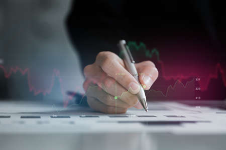 A business woman examines data on financial documents, company financial reports, graphics showing...