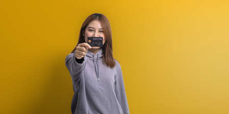 Portrait of Asian woman holding a credit card, credit card spending concept, online payment and...