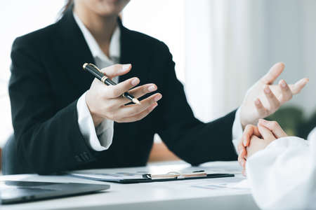 Company meeting room has businessmen and finance managers meeting together on finance topics, they are looking at information on documents and discussing together. Concept company financial managementの写真素材